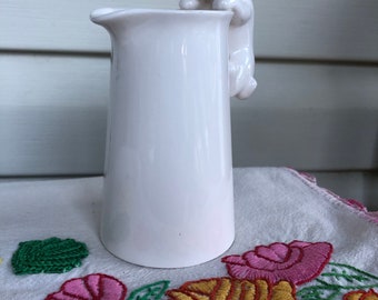 Small creamer/pitcher with cat peering over side.