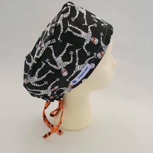Chirurgische Bindemütze von BrightCaps, Schwarze Halloween Mumie mit kontrastierenden orangefarbenen Fledermaus Bindebändern