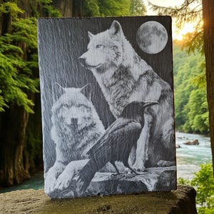 Peut inclure: Plaque rectangulaire en ardoise avec un motif gravé de deux loups et d'un corbeau sous une pleine lune. Les loups sont détaillés dans des tons de gris, et le corbeau est noir. Le fond est gris foncé.