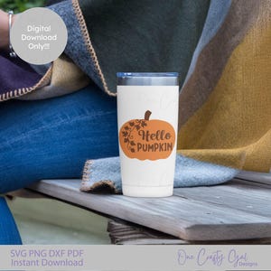 Könnte beinhalten: Ein weißer Becher mit blauem Deckel, verziert mit einem orangefarbenen Kürbis und den Worten "Hello Pumpkin". Der Becher steht auf einer Holzoberfläche, mit einer Decke im Hintergrund. Das Bild enthält auch den Text "SVG PNG DXF PDF Instant Download".