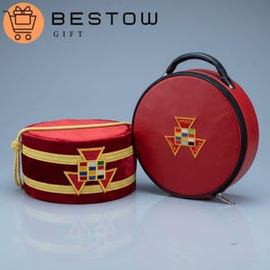 May include: A red velvet hat and matching round case with gold trim and embroidered emblems. The hat has a gold rope detail. The case has a black handle and zipper. The text "BESTOW GIFT" is in the upper left corner.