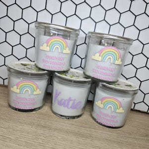May include: Five glass jar candles with silver lids. Each candle features a rainbow design and the text "THANK YOU FOR MAKING A DIFFERENCE". One candle is personalized with the name "Katie" in purple.
