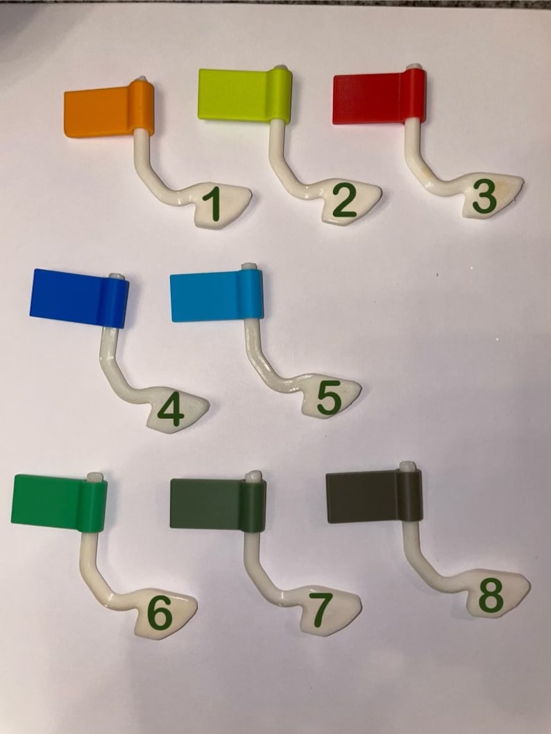 May include: Eight colorful flags with numbers 1 through 8 on a white background. The flags are attached to white plastic holders.