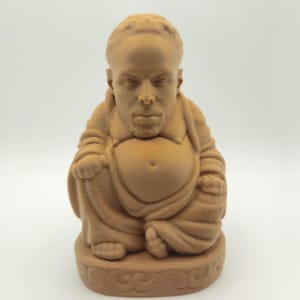 Peut inclure: Statue de Bouddha marron avec un visage humain, assis en méditation. La figurine porte des robes et repose sur une base décorative. La statue, probablement imprimée en 3D, est un objet décoratif unique.
