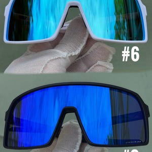 May include: Two pairs of sports sunglasses. One pair has a white frame with blue mirrored lenses, and the other has a black frame with blue mirrored lenses. The number "#6" is printed on the white frame, and "#3" is printed on the black frame.
