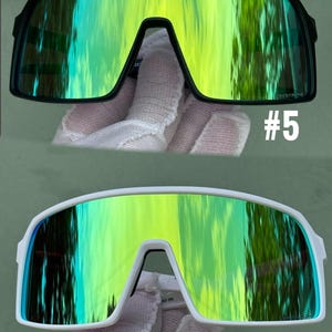 May include: Two pairs of sports sunglasses. One pair has a black frame with green and yellow lenses, labeled #5. The other pair has a white frame with green and yellow lenses, labeled #7. Both pairs have a modern, wraparound design.