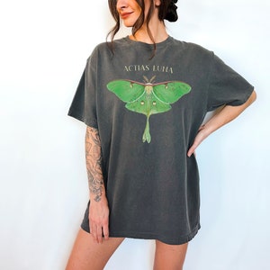 May include: A dark gray oversized t-shirt with a green luna moth graphic and the text "Actias Luna" printed on the front.