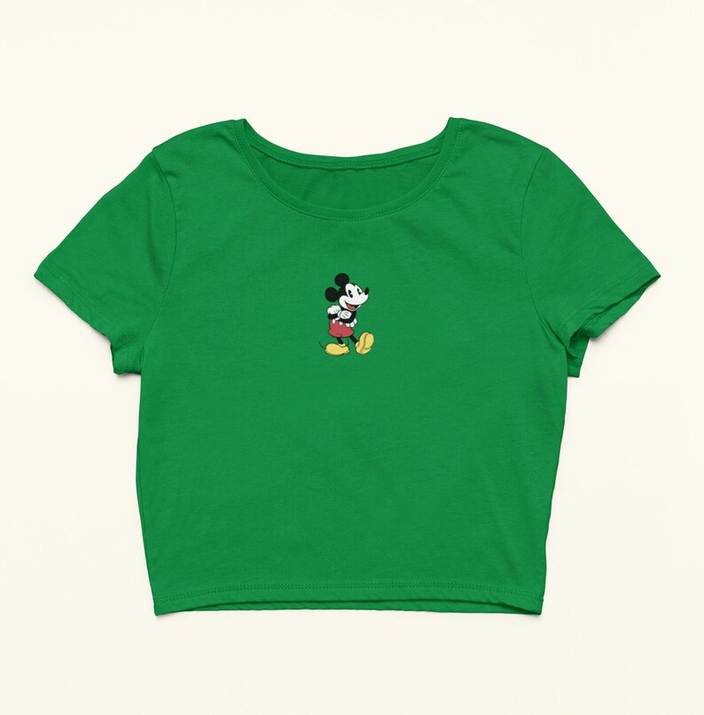 Peut inclure: Un t-shirt court vert avec une petite image brod&eacute;e de Mickey Mouse sur la poitrine gauche.