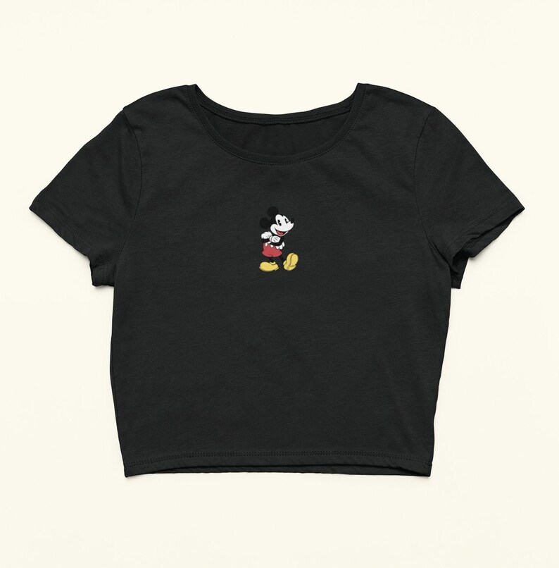 Peut inclure: T-shirt noir &agrave; manches courtes et coupe courte avec une petite image brod&eacute;e de Mickey Mouse au centre.