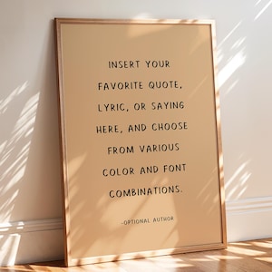 May include: A framed print with a tan background and black text. The text reads: "INSERT YOUR FAVORITE QUOTE, LYRIC, OR SAYING HERE, AND CHOOSE FROM VARIOUS COLOR AND FONT COMBINATIONS." The bottom of the print says "-OPTIONAL AUTHOR."