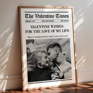 May include: A framed black and white Valentine's Day newspaper print. The headline reads "The Valentine Times" with the date and location. The main text says "Valentine Wishes: For the Love of My Life." A photo of a couple kissing is below the text.