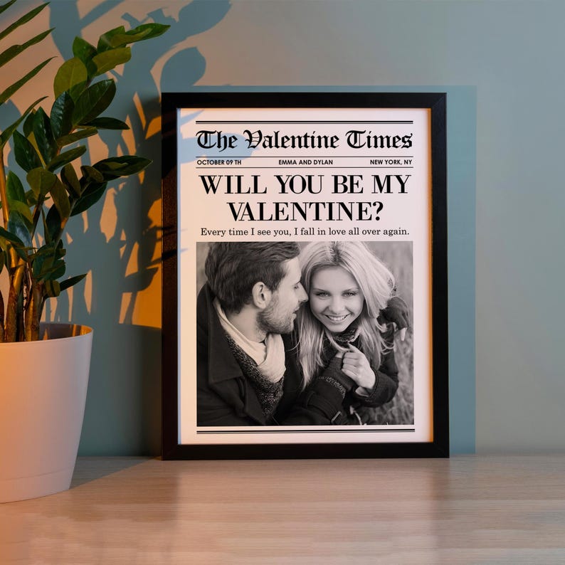 May include: A framed black and white photograph with the headline "The Valentine Times" and the question "Will You Be My Valentine?" The photo features a couple and the text "Every time I see you, I fall in love all over again."
