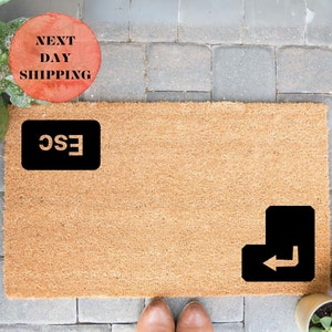 May include: A brown coir doormat with the words "ESC" and a black arrow key graphic.