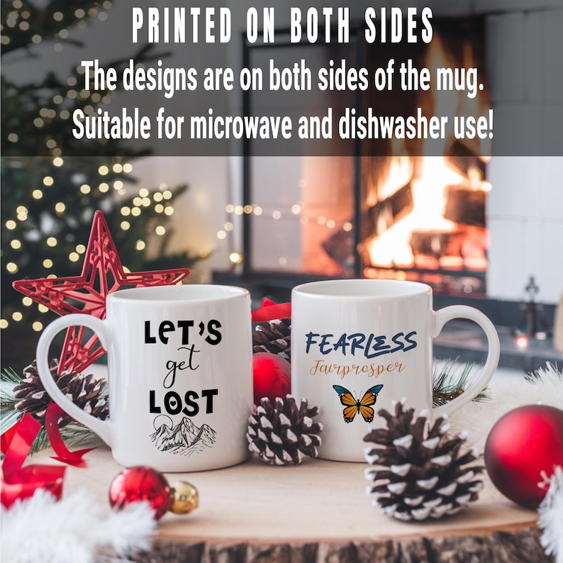 May include: Two white ceramic mugs with black text and designs. The mug on the left says "Let's get lost" with a mountain range design. The mug on the right says "Fearless Fairprosper" with a butterfly design.
