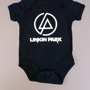 Könnte beinhalten: Schwarzer Baby-Body mit weißem Linkin Park-Logo. Das Logo zeigt einen Kreis mit einem Dreieck darin und den Namen der Band darunter. Der Body hat kurze Ärmel und Druckknöpfe am unteren Saum.