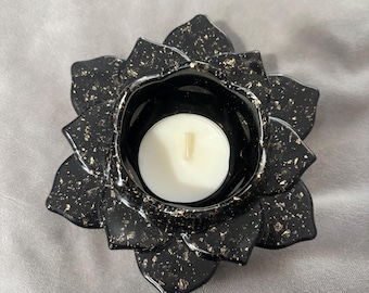 Puede incluir: Portavelas de cerámica negro en forma de flor de loto con motas doradas. El portavelas tiene una pequeña depresión redonda en el centro para una vela de té.