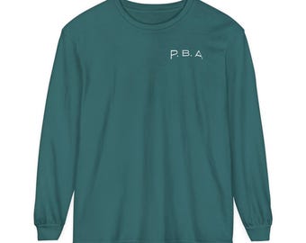 May include: Teal long-sleeve shirt with the text "P.B.A." printed on the front.