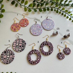 May include: Ten pairs of colorful geometric patterned earrings. The earrings are made of polymer clay and have gold hooks. The earrings are numbered 1 through 5.