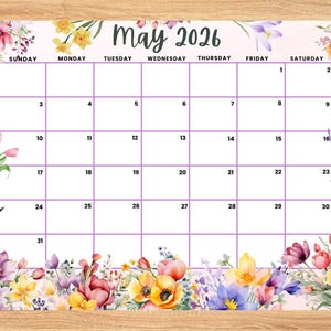 May include: A floral-themed May 2026 calendar with a light pink background. The calendar grid is purple, and the top and bottom borders are decorated with watercolor flowers. Two pencils are on the wooden surface.