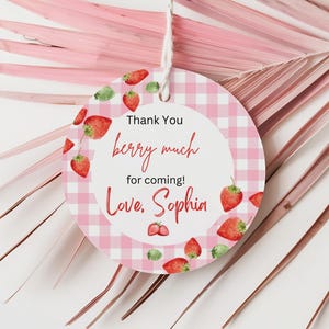 May include: Pink and white gingham circle tag with red strawberries and the text "Thank You berry much for coming! Love, Sophia"