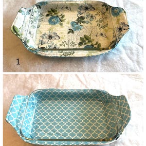 May include: Rectangular glass baking dish with floral and butterfly pattern. The dish has a light blue, green, and white color scheme. The handles are covered with a matching fabric. The second image shows a blue and white geometric pattern.