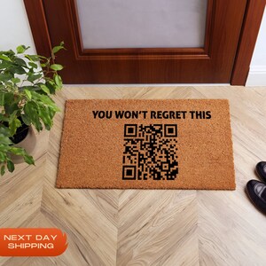May include: A brown coir doormat with the text "YOU WON'T REGRET THIS" and a black and white QR code.