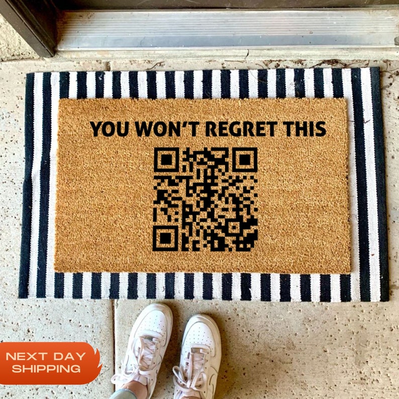 May include: A brown coir doormat with black text that reads "YOU WON'T REGRET THIS" and a black QR code.