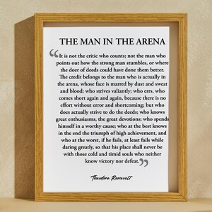 May include: A framed print with a black and white quote by Theodore Roosevelt about the importance of action and perseverance. The quote reads, "It is not the critic who counts; not the man who points out how the strong man stumbles, or where the doer of deeds could have done them better. The credit belongs to the man who is actually in the arena, whose face is marred by dust and sweat and blood; who strives valiantly; who errs, who comes short again and again, because there is no effort without error and shortcoming; but who does actually strive to do the deeds; who knows great enthusiasms, the great devotions; who spends himself in a worthy cause; who at the best knows in the end the triumph of high achievement, and who at the worst, if he fails, at least fails while daring greatly, so that his place shall never be with those cold and timid souls who neither know victory nor defeat."
