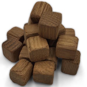 May include: A pile of small, square wooden blocks. The blocks are a warm brown color with visible wood grain and texture. They appear to be made of oak or a similar hardwood. The blocks are stacked together, creating a textured surface.