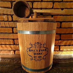 Könnte beinhalten: Ein Holzfass mit einem Metallband und einem Holzdeckel. Das Fass ist mit dem Text "Roll's Farm 'Seana' Est 2018" graviert. Ein Holzlöffel mit Griff liegt auf dem Deckel.