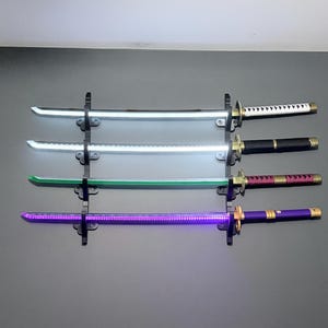 May include: Four katana swords mounted horizontally on a black wall rack. The top sword has a white handle, the second a black handle, the third a magenta handle, and the bottom a purple handle. Each blade glows with a distinct light color.