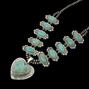 Op de afbeelding: Een zilveren ketting met een hartvormige turquoise hanger en ovale turquoise stenen gezet in zilver.