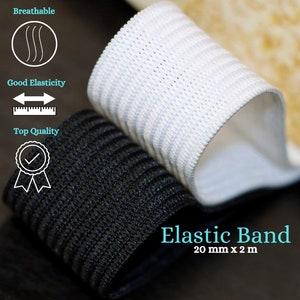 Könnte beinhalten: Nahaufnahme von zwei Rollen Gummiband, eine schwarze und eine weiße. Das weiße Band liegt oben, teilweise abgerollt und zeigt eine atmungsaktive, strukturierte Oberfläche. Das Bild enthält Text "Elastic Band 20 mm x 2 m" und Symbole.