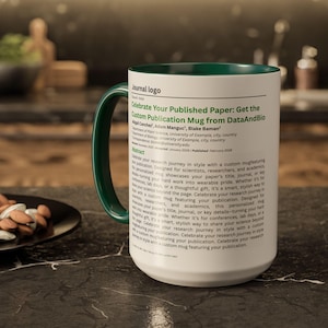 Può includere: Tazza in ceramica bianca con manico e interno verdi. La tazza presenta il testo "Celebra il tuo articolo pubblicato: Ottieni la tazza di pubblicazione personalizzata da DataAndBio". La tazza è progettata per scienziati e accademici.