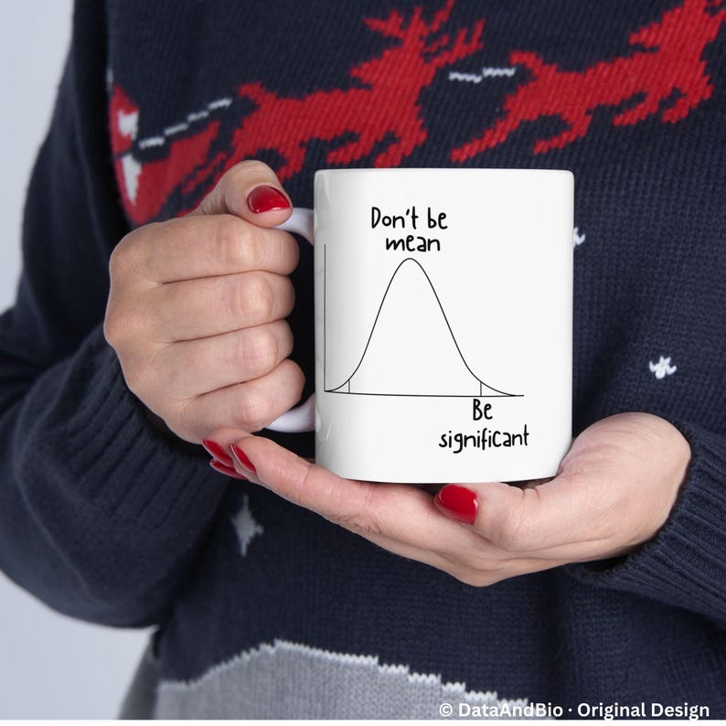 May include: A white ceramic mug featuring a black line drawing of a bell curve distribution graph. The text above the curve reads Don't be mean and the text below the curve reads Be significant. The mug has a simple handle and a smooth finish.