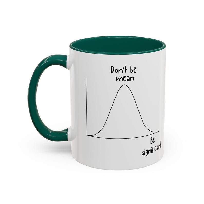 May include: A white ceramic mug with a dark green handle and interior. The exterior features a black line drawing of a bell curve graph with the text "Don't be mean" above the peak and "Be significant" near the tail of the distribution.