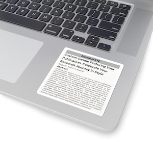 May include: A white sticker on a laptop featuring text that reads "Custom Candle Featuring Your Publication: Celebrate Your Research Journey in Style." The sticker has a gray border and includes the journal name and abstract.