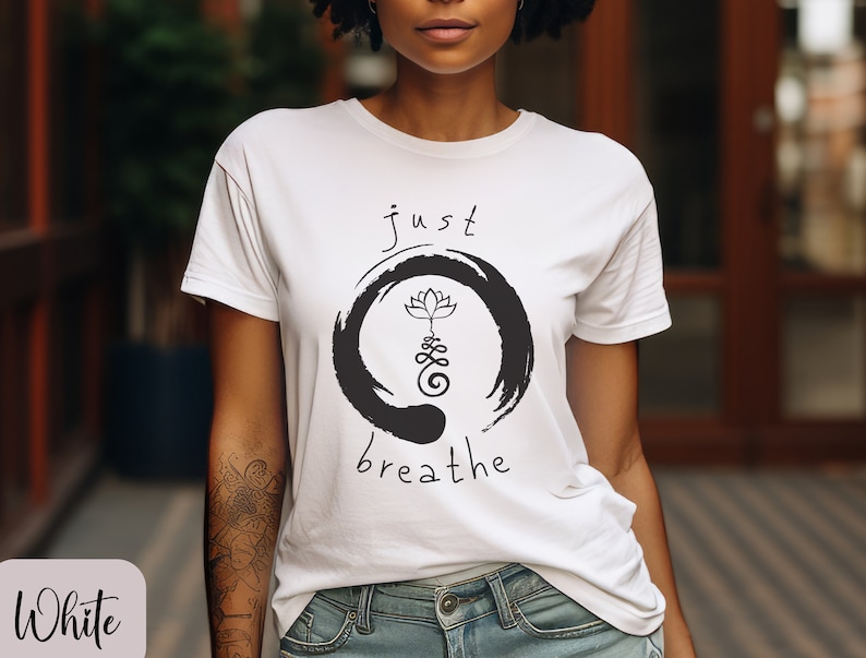 May include: White t-shirt with a black and white graphic design featuring a lotus flower and the text "just breathe".
