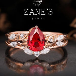 Bröllopspresent i massivt guld, förlovningsring i fyrverkeri-stil med päron och röd rubin, vigselring med blomkvist, present till mor med födelsesten, ring för kärlek