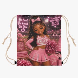 May include: A drawstring bag featuring a graphic of a cheerleader in a pink uniform with a pom-pom. Text includes Be Loud Be Proud Be You, Teamwork Confidence Believe Achieve, She Believed She Could So She Cheered, Confidence, Courage, Spirit, Dedication.
