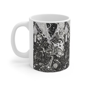 May include: White ceramic coffee mug featuring a detailed black and white illustration. The artwork depicts a whimsical scene with figures, stars, and intricate patterns. The mug has a curved handle and a glossy finish.