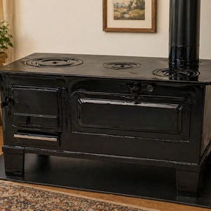 Puede incluir: Una estufa antigua negra con un acabado brillante. La estufa tiene tres quemadores circulares en la parte superior y una puerta con un asa. Una chimenea negra se eleva de la estufa. La estufa está sobre una alfombra negra en una habitación con una alfombra y una cesta de mimbre.