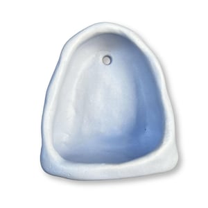 以下が含まれることがあります： 淡い青色のセラミック製ウォールポケット。丸みを帯びた有機的な形状で、上部に吊り下げ用の小さな穴があります。内側は少し濃い青色で、微妙なコントラストを生み出しています。シンプルでモダンなデザインです。