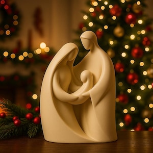 Może przedstawiać: Kremowa figurka szopki przedstawiająca Marię, Józefa i małego Jezusa. Postacie są stylizowane z płynącymi szatami, a rodzina się obejmuje. Tło obejmuje choinkę z czerwonymi i złotymi ozdobami oraz miękkimi światłami bokeh.