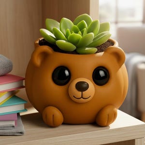 May include: A brown bear-shaped planter with large black eyes, a small nose, and a smiling mouth. The planter holds a green succulent plant. The planter has small paws and ears. The planter is sitting on a wooden shelf.