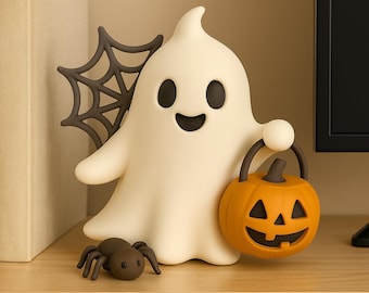Puede incluir: Una figura de fantasma blanco con ojos negros y boca sonriente, sosteniendo un cubo de calabaza naranja. También hay una araña gris oscuro y una telaraña, creando un tema de Halloween.