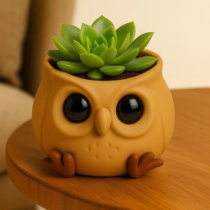 May include: A whimsical owl-shaped planter in a warm yellow hue, featuring large black eyes and small brown feet. The planter holds a vibrant green succulent, creating a charming decorative piece for home or office. The planter is sitting on a wooden table.
