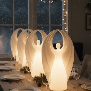 Könnte beinhalten: Ein festlich gedeckter Esstisch mit vier engelsförmigen Lampen, die jeweils ein warmes Licht ausstrahlen. Die Lampen sind weiß und mit Weingläsern, Tellern und Besteck angeordnet. Der Tisch ist aus Holz.