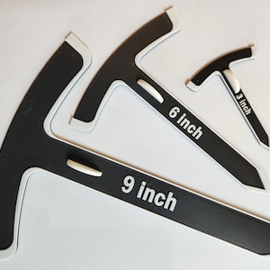 May include: Three black and white plastic protractors with white markings. The protractors are labelled 3 inch, 6 inch, and 9 inch.