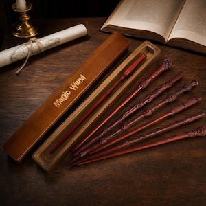 May include: A set of six reddish-brown wooden wands with varied carved textures and a matching rectangular wooden storage box featuring the gold-colored text MAGIC WAND engraved on the lid, arranged on a dark wooden surface.
